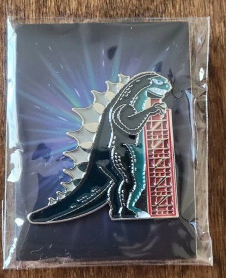 Black Godzilla enamel pin on starburst backing card in protective plastic
